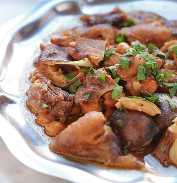 Pour les amateurs d'abats, voici un ragoût de tête et pieds de mouton dans une sauce rouge avec des pois chiches et des épices. Un plat classique algérien appelé chtitha bouzellouf en arabe. C'est une recette qui se fait en particulier à la fête du mouton (ou Aid el Adha). C'est simple, facile à faire et vraiment savoureux. 