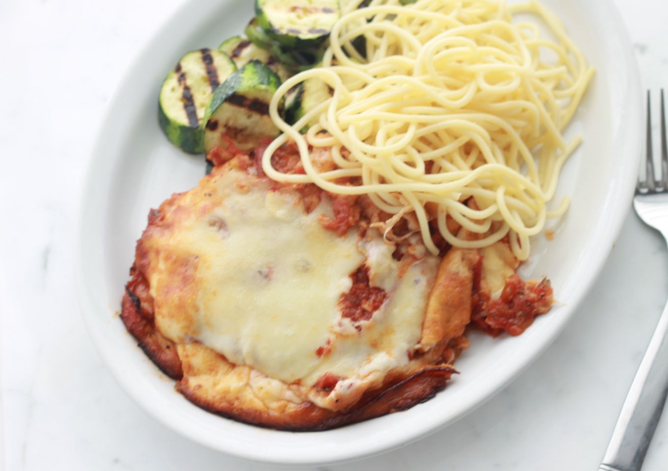 Escalopes de poulet panées avec un mélange de parmesan et de chapelure. Elles sont frites puis passées au four avec de la sauce tomate et du fromage. / cuisineculinaire.com