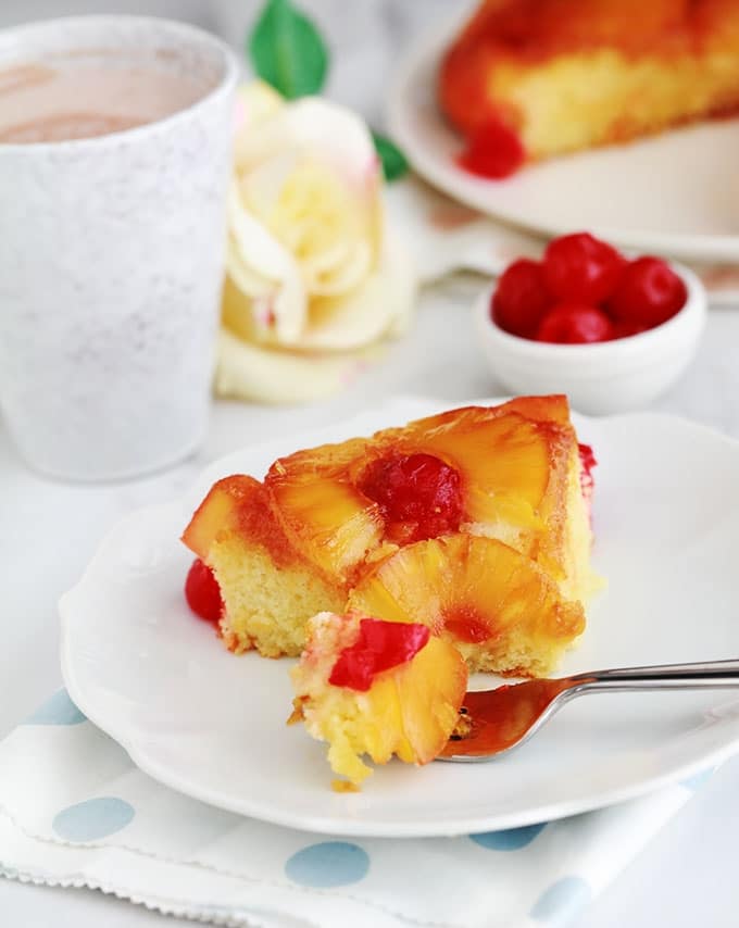 Délicieux gâteau au yaourt renversé à l'ananas et cerises confites caramélisés. Une variante classique à base de la fameuse recette du gâteau au yaourt. Très moelleux et facile à faire. Vous pouvez le réaliser avec de l'ananas en boîte (coupé en tranches ou en dés) ou encore de l'ananas frais. Pour le goûter ou en dessert.