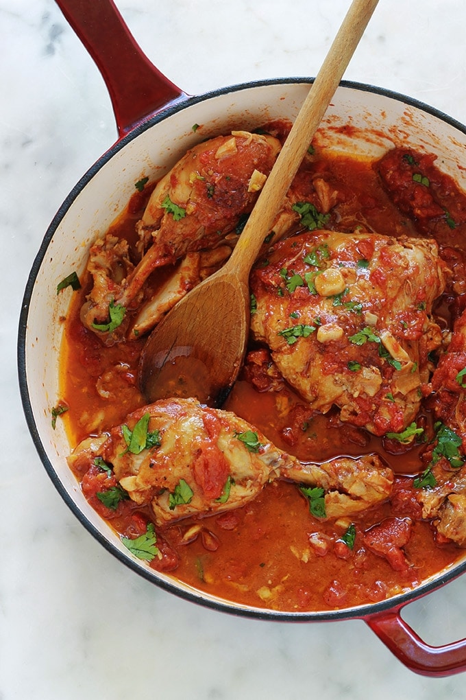 Cette recette de poulet à l’ail et tomates me vient de ma mère. C’est un plat savoureux et économique. Ce sont des morceaux de poulet cuits lentement et longuement dans une cocotte ou une grande poêle avec de l’ail et des tomates. Pas besoin de laisser mariner le poulet au préalable. Après cuisson, le poulet est très tendre, juteux et plein de saveurs.