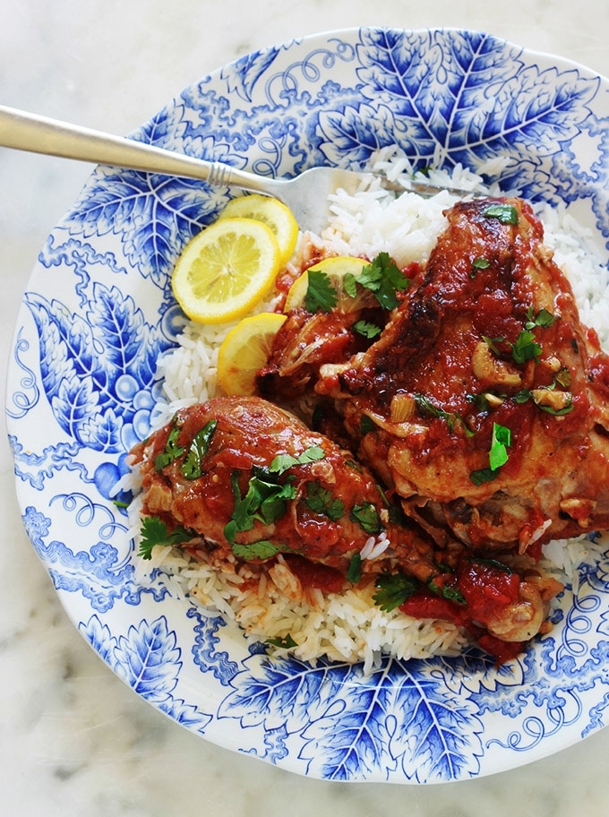 Cette recette de poulet à l’ail et tomates me vient de ma mère. C’est un plat savoureux et économique. Ce sont des morceaux de poulet cuits lentement et longuement dans une cocotte ou une grande poêle avec de l’ail et des tomates. Pas besoin de laisser mariner le poulet au préalable. Après cuisson, le poulet est très tendre, juteux et plein de saveurs.