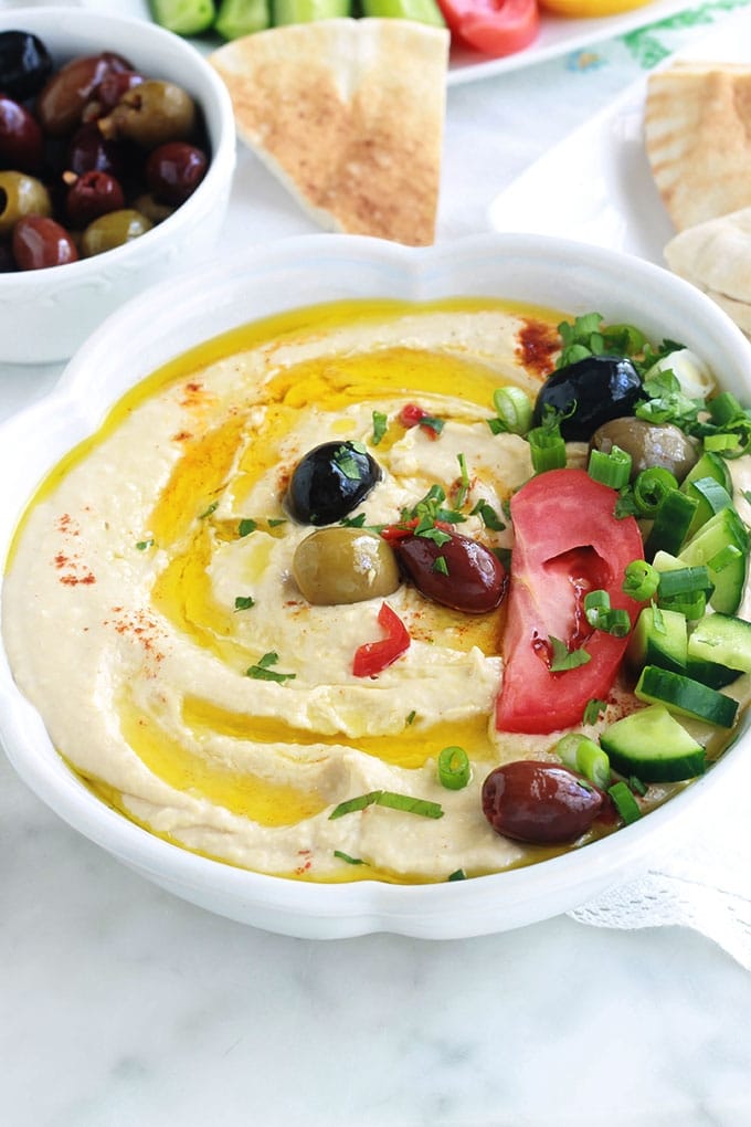 La recette du houmous traditionnel libanais. Une dip santé très populaire : purée de pois chiches à la crème de sésame ou tahini. Peu d'ingrédients : pois chiches, crème de sésame (tahina), ail, jus de citron. Pour servir : de l'huile d'olive et éventuellement des épices, herbes aromatiques et légumes. Il est très facile et rapide. Prêt en moins de 5 minutes!