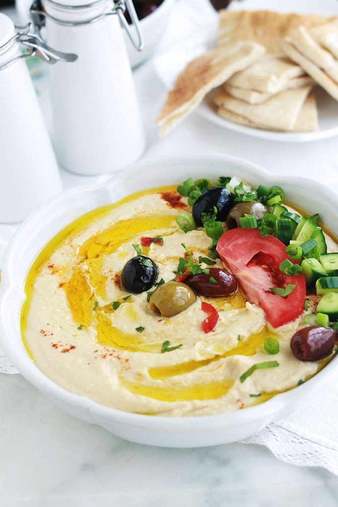 La recette du houmous traditionnel libanais. Une dip santé très populaire : purée de pois chiches à la crème de sésame ou tahini. Peu d'ingrédients : pois chiches, crème de sésame (tahina), ail, jus de citron. Pour servir : de l'huile d'olive et éventuellement des épices, herbes aromatiques et légumes. Il est très facile et rapide. Prêt en moins de 5 minutes!