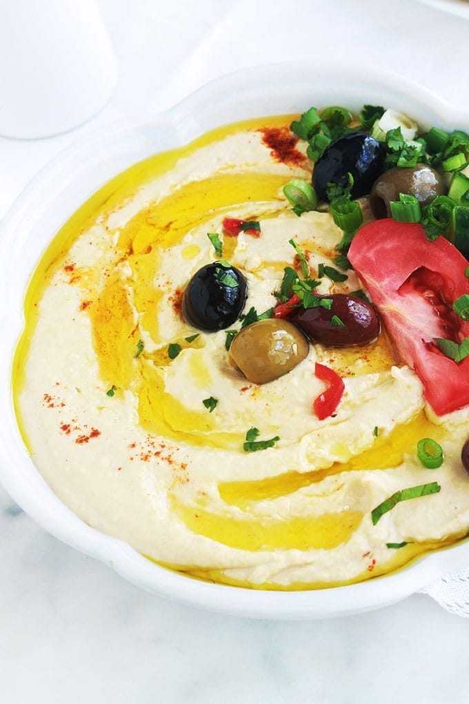 La recette du houmous traditionnel libanais. Une dip santé très populaire : purée de pois chiches à la crème de sésame ou tahini. Peu d'ingrédients : pois chiches, crème de sésame (tahina), ail, jus de citron. Pour servir : de l'huile d'olive et éventuellement des épices, herbes aromatiques et légumes. Il est très facile et rapide. Prêt en moins de 5 minutes!