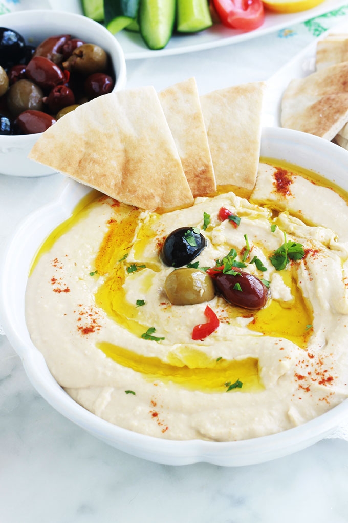 La recette du houmous traditionnel libanais. Une dip santé très populaire : purée de pois chiches à la crème de sésame ou tahini. Peu d'ingrédients : pois chiches, crème de sésame (tahina), ail, jus de citron. Pour servir : de l'huile d'olive et éventuellement des épices, herbes aromatiques et légumes. Il est très facile et rapide. Prêt en moins de 5 minutes!