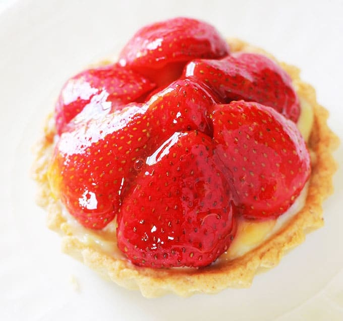 Recette des tartelettes aux fraises et crème pâtissière. Très faciles à faire et rapides. Avec la pâte sablée sucrée de Pierre Hermé. Pour gagner du temps, préparez vos fonds de tartelettes à l'avance.Il faut le dire, ces tartelettes ont un charme fou, et elles ne sont pas trop sucrées!