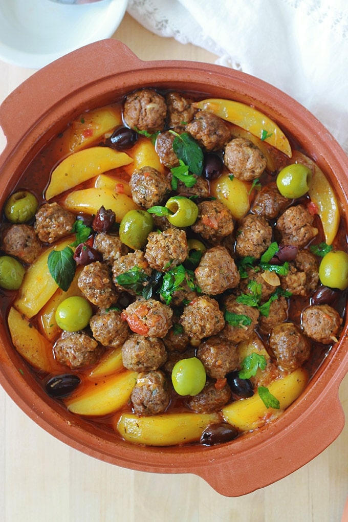 Tajine aux boulettes de viande, pommes de terre et olives. Le tout est cuit dans une sauce tomate. Si vous n'avez pas de tajine en terre cuite, pas de problème. Utilisez une cocotte ou une grande poêle avec couvercle. Un plat simple, complet et réconfortant. 