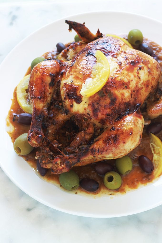 Recette du poulet à la marocaine au citron confit et olives (ou poulet mhamer, poulet maqli). Le poulet est mariné dans une sauce chermoula : coriandre, persil, épices, citron confit, ail, oignons et huile d'olive. Accompagnement : frites ou des pommes de terre sautées, pain, riz, pâtes, couscous, etc