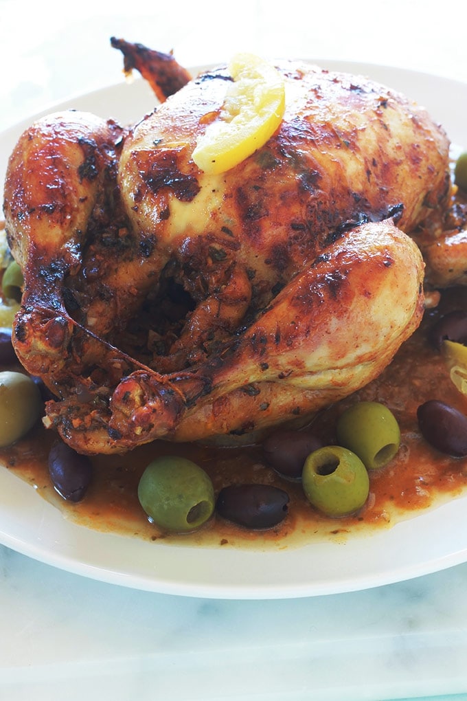 Recette du poulet à la marocaine au citron confit et olives (ou poulet mhamer, poulet maqli). Le poulet est mariné dans une sauce chermoula : coriandre, persil, épices, citron confit, ail, oignons et huile d'olive. Accompagnement : frites ou des pommes de terre sautées, pain, riz, pâtes, couscous, etc