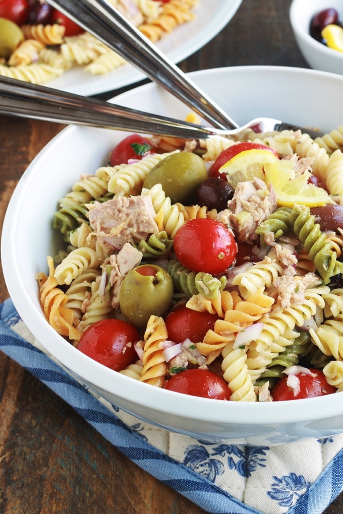 Délicieuse salade de pâtes au thon toute simple, parfumée, avec une vinaigrette aux herbes fines. Une recette facile et rapide à faire.  C'est une salade repas froide, parfaite pour l'été. Composée de pâtes fusilli 3 couleurs, thon en boîte, tomates, oignon, olives, vinaigrette aux herbes aromatiques.