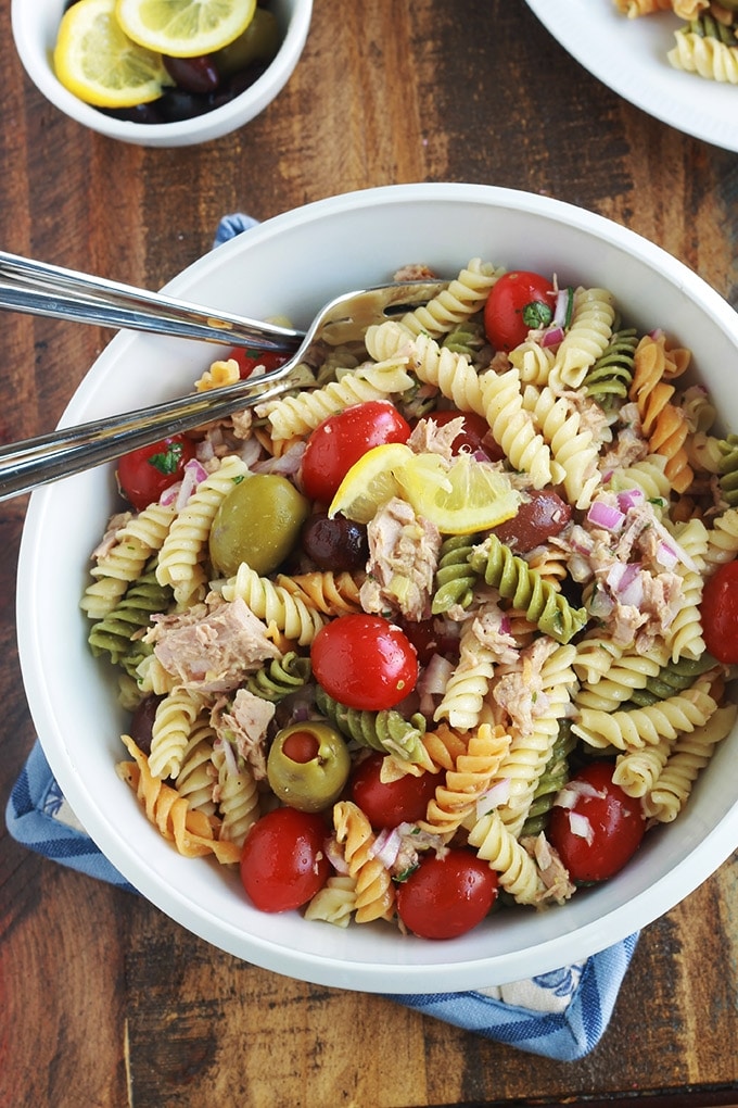 Délicieuse salade de pâtes au thon toute simple, parfumée, avec une vinaigrette aux herbes fines. Une recette facile et rapide à faire.  C'est une salade repas froide, parfaite pour l'été. Composée de pâtes fusilli 3 couleurs, thon en boîte, tomates, oignon, olives, vinaigrette aux herbes aromatiques.