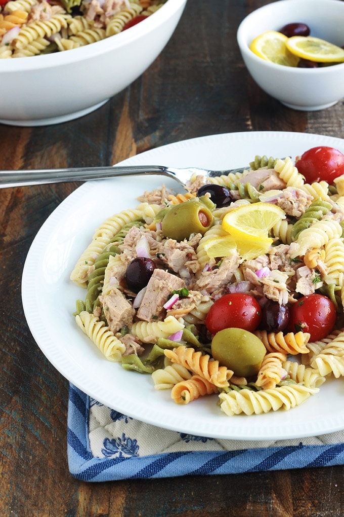 Délicieuse salade de pâtes au thon toute simple, parfumée, avec une vinaigrette aux herbes fines. Une recette facile et rapide à faire.  C'est une salade repas froide, parfaite pour l'été. Composée de pâtes fusilli 3 couleurs, thon en boîte, tomates, oignon, olives, vinaigrette aux herbes aromatiques.