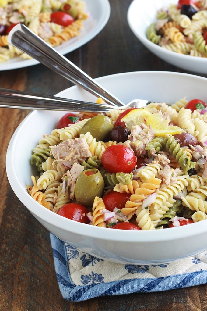 Délicieuse salade de pâtes au thon toute simple, parfumée, avec une vinaigrette aux herbes fines. Une recette facile et rapide à faire.  C'est une salade repas froide, parfaite pour l'été. Composée de pâtes fusilli 3 couleurs, thon en boîte, tomates, oignon, olives, vinaigrette aux herbes aromatiques.