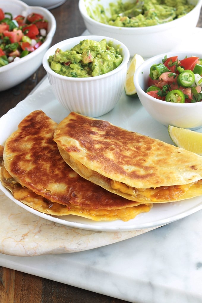 Apprenez comment faire les quesadillas mexicaines. C’est facile, rapide et vous pouvez les garnir de mille et une façons, avec ou sans viande. Ce sont des tortillas mexicaines, garnies de fromage, et éventuellement des légumes et/ou protéine : viande, poulet, poisson ou fruits de mer. Accompagnées d’une sauce, elles font un goûter ou plat rapide et complet.