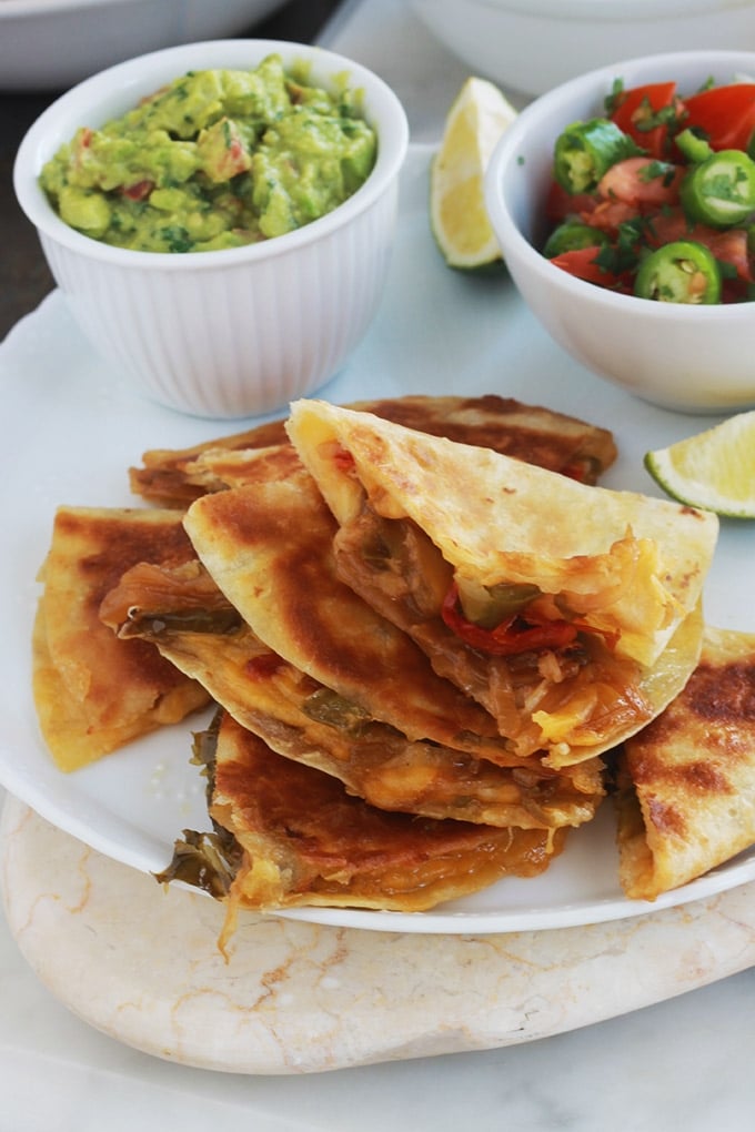 Apprenez comment faire les quesadillas mexicaines. C’est facile, rapide et vous pouvez les garnir de mille et une façons, avec ou sans viande. Ce sont des tortillas mexicaines, garnies de fromage, et éventuellement des légumes et/ou protéine : viande, poulet, poisson ou fruits de mer. Accompagnées d’une sauce, elles font un goûter ou plat rapide et complet.