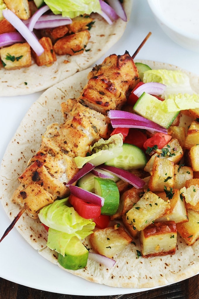 Pain pita au brochettes de poulet mariné à la libanaise (chich taouk), des pommes de terre frites épicées en sauce citronnée à l’ail et coriandre, des crudités et une sauce blanche. Une recette toute simple, facile et délicieuse.