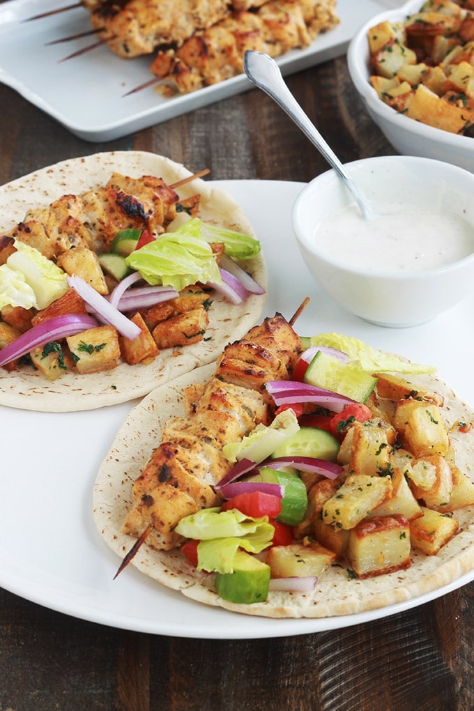 Pain pita au brochettes de poulet mariné à la libanaise (chich taouk), des pommes de terre frites épicées en sauce citronnée à l’ail et coriandre, des crudités et une sauce blanche. Une recette toute simple, facile et délicieuse.