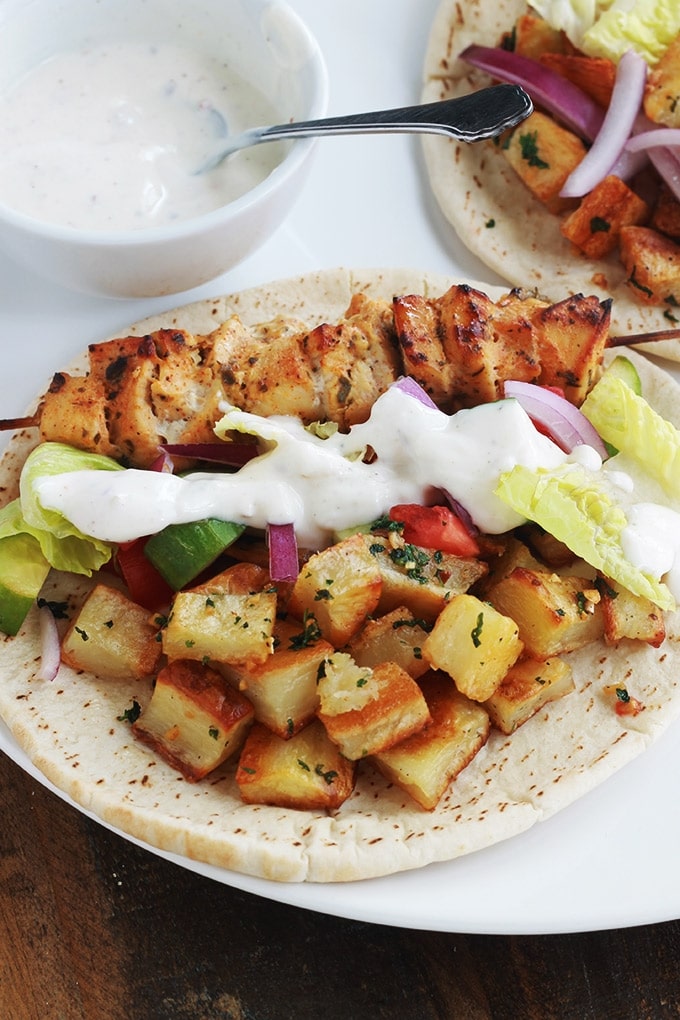 Pain pita au brochettes de poulet mariné à la libanaise (chich taouk), des pommes de terre frites épicées en sauce citronnée à l’ail et coriandre, des crudités et une sauce blanche. Une recette toute simple, facile et délicieuse.