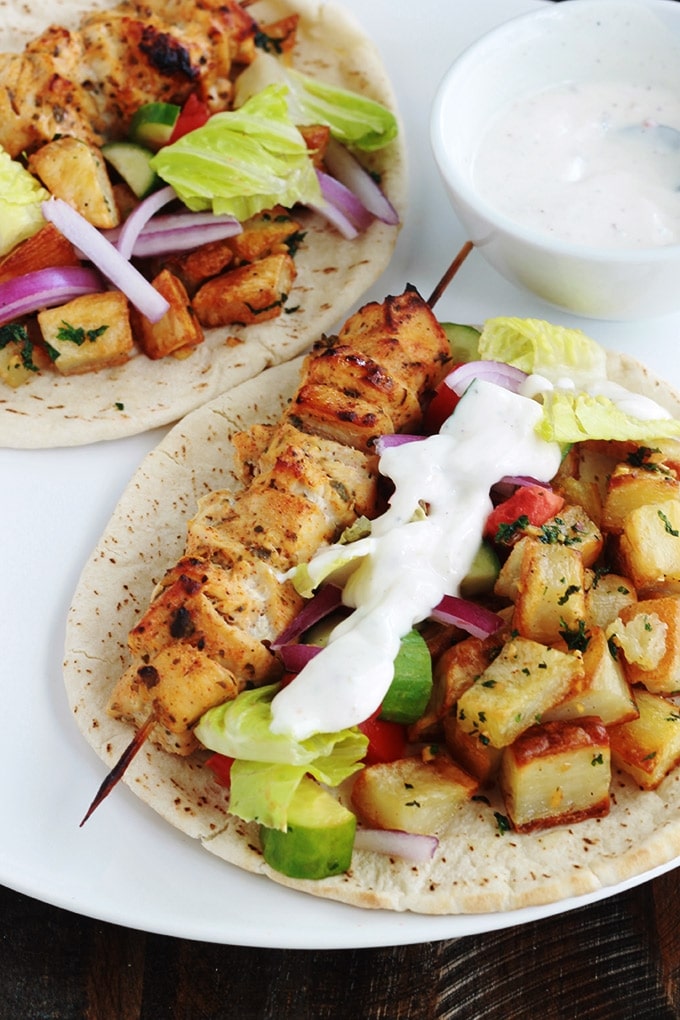 Pain pita au brochettes de poulet mariné à la libanaise (chich taouk), des pommes de terre frites épicées en sauce citronnée à l’ail et coriandre, des crudités et une sauce blanche. Une recette toute simple, facile et délicieuse.