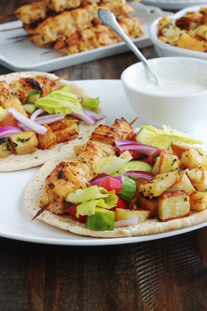 Pain pita au brochettes de poulet mariné à la libanaise (chich taouk), des pommes de terre frites épicées en sauce citronnée à l’ail et coriandre, des crudités et une sauce blanche. Une recette toute simple, facile et délicieuse.