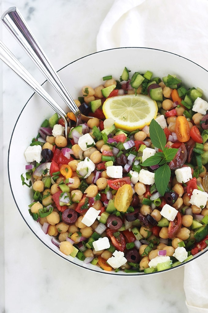 Salade de pois chiches à la grecque rafraîchissante. Une recette facile et rapide (5 minutes!). Des pois chiches, tomates, concombres, oignons, feta, olives kalamata et aromates. Le tout arrosé d’une vinaigrette grecque toute simple. C’est une salade économique, végétarienne et vegan (sans la feta!).