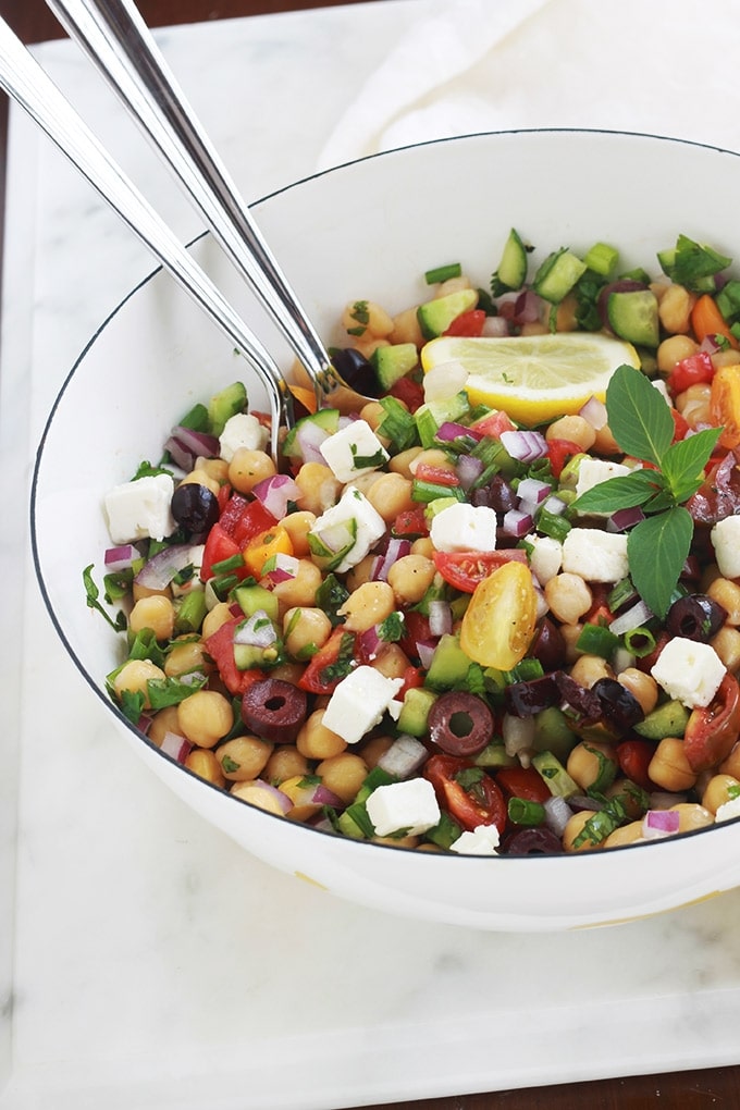 Salade de pois chiches à la grecque rafraîchissante. Une recette facile et rapide (5 minutes!). Des pois chiches, tomates, concombres, oignons, feta, olives kalamata et aromates. Le tout arrosé d’une vinaigrette grecque toute simple. C’est une salade économique, végétarienne et vegan (sans la feta!).