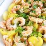 Cette salade de pommes de terre aux crevettes (ou scampis) est très simple et tellement goûteuse. Une recette facile pour un repas rapide prêt en quelques minutes ! Pommes de terre, crevettes, oignons verts, persil, vinaigrette au citron et moutarde. Yummy!