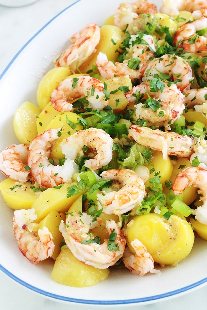 Cette salade de pommes de terre aux crevettes (ou scampis) est très simple et tellement goûteuse. Une recette facile pour un repas rapide prêt en quelques minutes ! Pommes de terre, crevettes, oignons verts, persil, vinaigrette au citron et moutarde. Yummy!