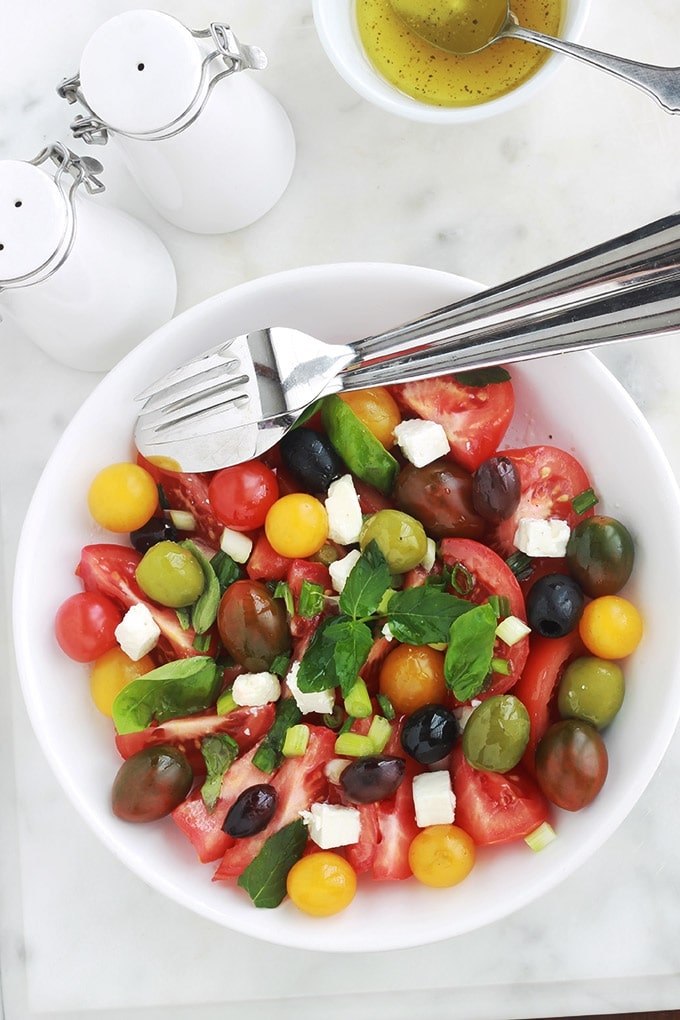 Délicieuse salade de tomates avec du fromage feta, des olives et du basilic. Le tout arrosé d’une vinaigrette toute simple. C’est l’une de mes salades estivales préférées, très parfumée, facile et rapide.