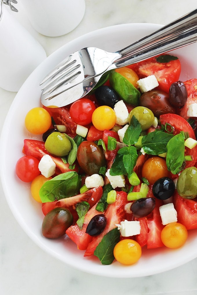 Délicieuse salade de tomates avec du fromage feta, des olives et du basilic. Le tout arrosé d’une vinaigrette toute simple. C’est l’une de mes salades estivales préférées, très parfumée, facile et rapide.