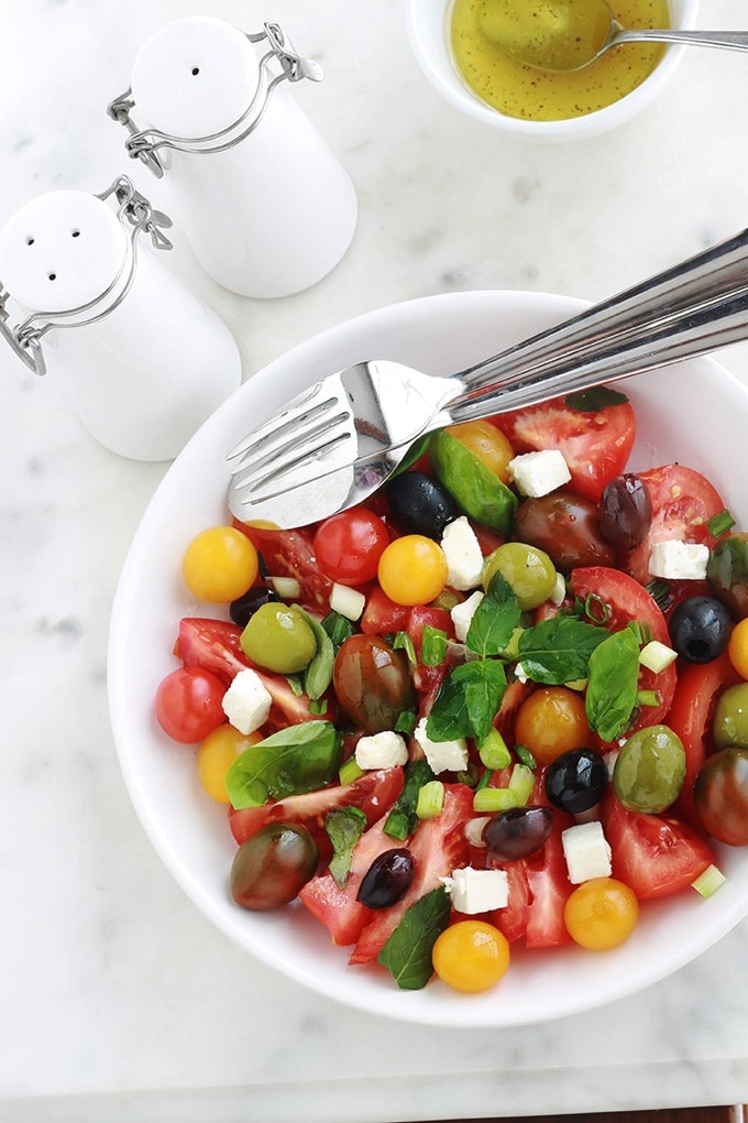 Délicieuse salade de tomates avec du fromage feta, des olives et du basilic. Le tout arrosé d’une vinaigrette toute simple. C’est l’une de mes salades estivales préférées, très parfumée, facile et rapide.