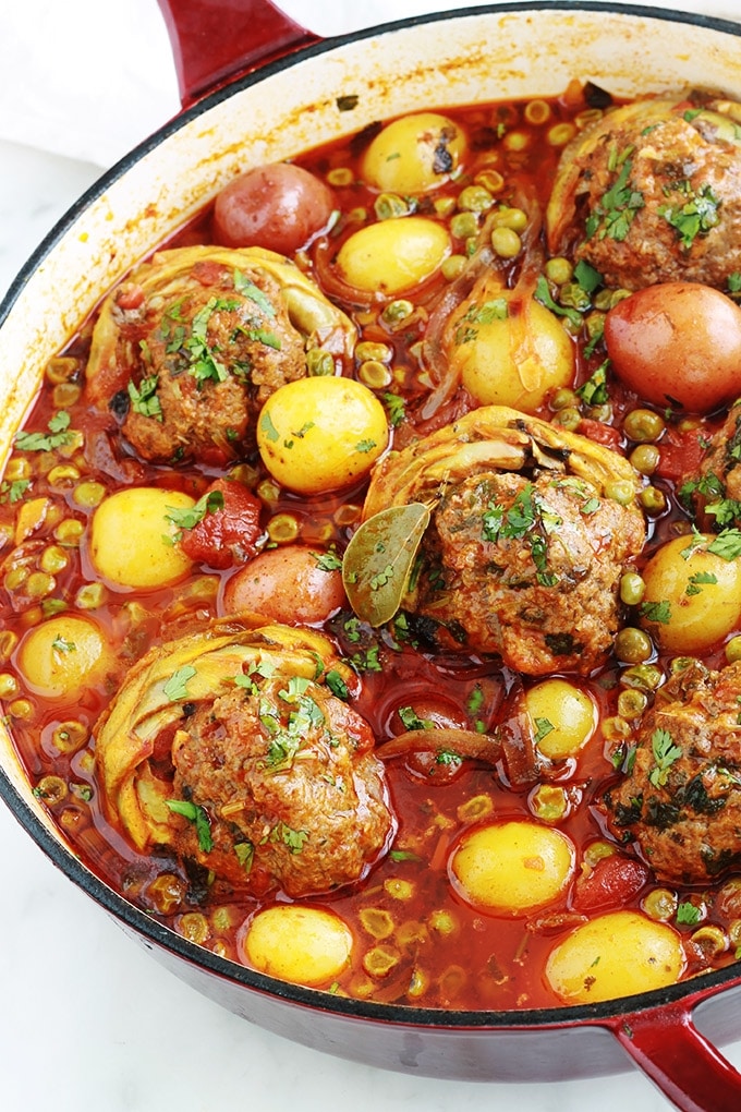 Voici un plat complet de légumes mijotés dans une sauce tomate : des fonds d'artichauts farcis à la viande hachée, des pommes de terre et des petits pois. Une recette facile, rapide et pleine de saveurs. Et vous pouvez l'adapter en mettant des légumes selon votre goût.