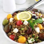 Salade de lentilles à la grecque, facile, très rapide et pleine de saveurs. Composée de lentilles, tomates, feta, concombre, oignons et olives, le tout arrosé d'une vinaigrette citronnée parfumée aux herbes aromatiques.