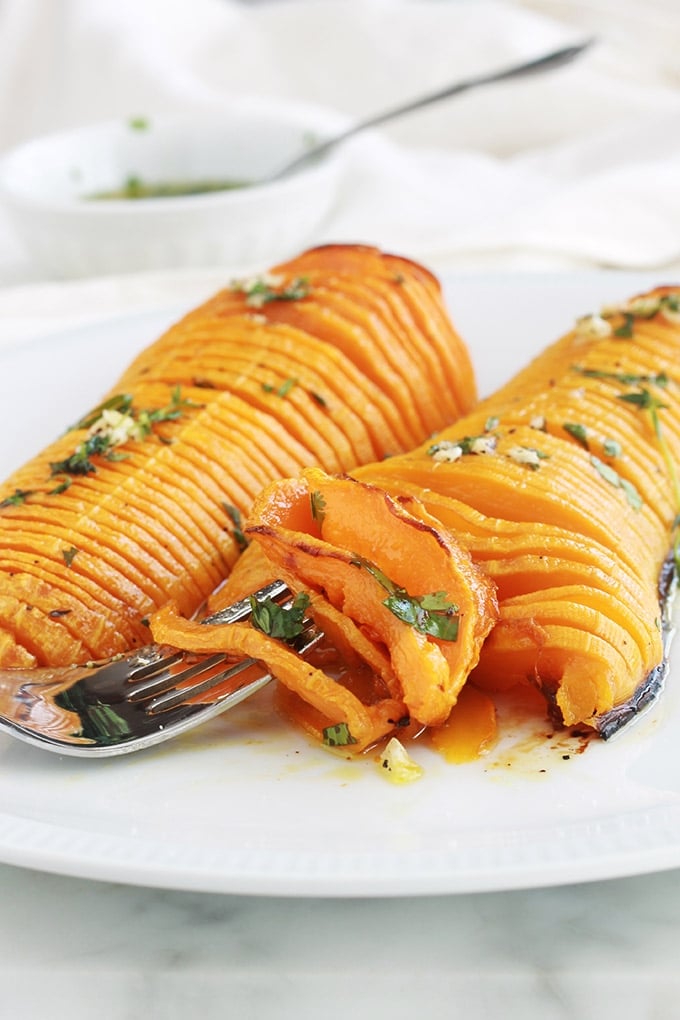 Voici une recette originale de courge butternut rôtie au four : à la hasselback! Simple et facile à faire. Ce sont des demi courges butternut (doubeurre) coupées en tranches (sans aller jusqu’au bout), assaisonnées avec des épices, herbes aromatiques et huile d’olive puis rôties au four. 