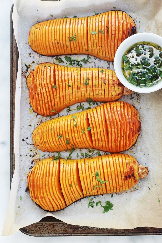 Voici une recette originale de courge butternut rôtie au four : à la hasselback! Simple et facile à faire. Ce sont des demi courges butternut (doubeurre) coupées en tranches (sans aller jusqu’au bout), assaisonnées avec des épices, herbes aromatiques et huile d’olive puis rôties au four. 