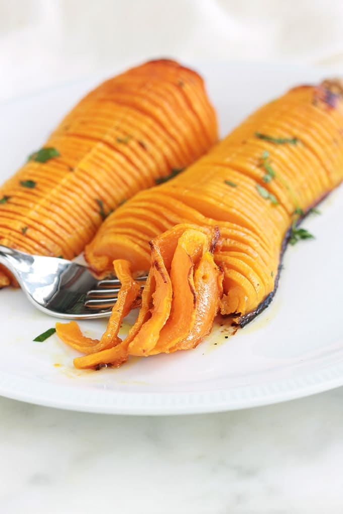 Voici une recette originale de courge butternut rôtie au four : à la hasselback! Simple et facile à faire. Ce sont des demi courges butternut (doubeurre) coupées en tranches (sans aller jusqu’au bout), assaisonnées avec des épices, herbes aromatiques et huile d’olive puis rôties au four. 