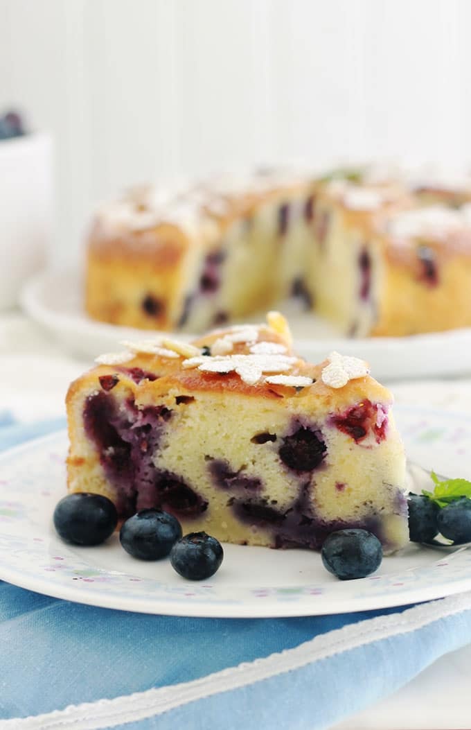 Encore un gâteau au yaourt hyper moelleux, aux myrtilles (ou bleuets) et amandes! Pot de yaourt (nature ou parfumé), myrtilles (fraîches, congelées ou au sirop), poudre d’amande et des amandes effilées. Une recette facile, gâteau gourmand et trop bon!