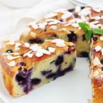 Encore un gâteau au yaourt hyper moelleux, aux myrtilles (ou bleuets) et amandes! Pot de yaourt (nature ou parfumé), myrtilles (fraîches, congelées ou au sirop), poudre d’amande et des amandes effilées. Une recette facile, gâteau gourmand et trop bon!