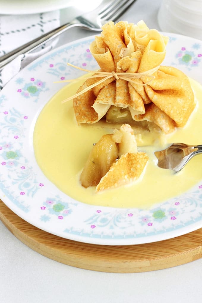 Délicieux dessert tout simple, chic et méga gourmand! Des aumônières de crêpes garnies de pommes caramélisées et présentées sur un fond de crème anglaise. La recette est très facile et vous pouvez préparer à l’avance les pommes caramélisées et la sauce pour sucrée. Superbes comme dessert pour votre repas de Noel ou de fin d'année!