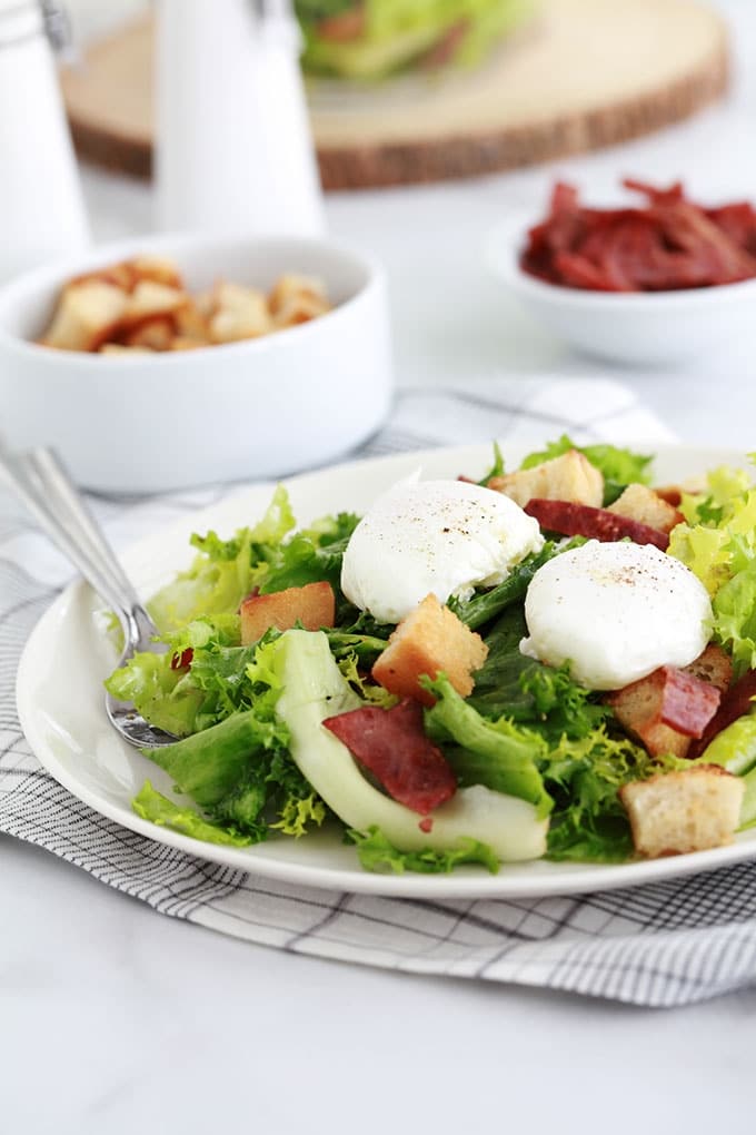 Salade frisée aux oeufs pochés, croûtons croustillants et lardons fumés de dinde. Recette simple et délicieuse. Peut servir de plat principal rapide et léger.