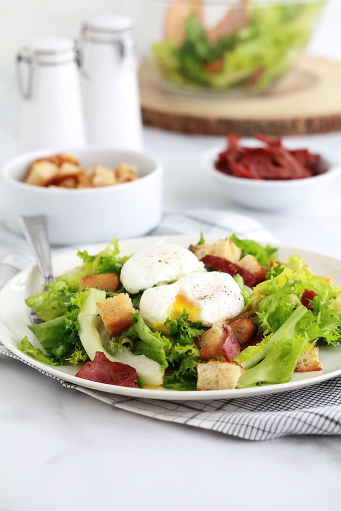 Salade frisée aux oeufs pochés, croûtons croustillants et lardons fumés de dinde. Recette simple et délicieuse. Peut servir de plat principal rapide et léger.