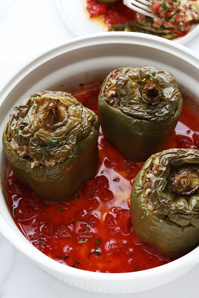 Ces poivrons verts farcis sont un plat complet très simple à faire. Farce à base de riz et de viande hachée. Ils sont cuits au four sur un lit de sauce tomate. Une recette anti-gaspillage qui vous permet d’utiliser un reste de riz cuit et éventuellement des restes de légumes.