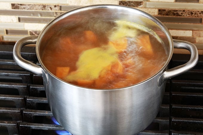 Cuisson de patates douces épluchées et coupées en cubes à l'eau bouillante.