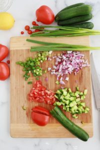 Couper les legumes en petits morceaux - concombre tomates oignon rouge oignons verts