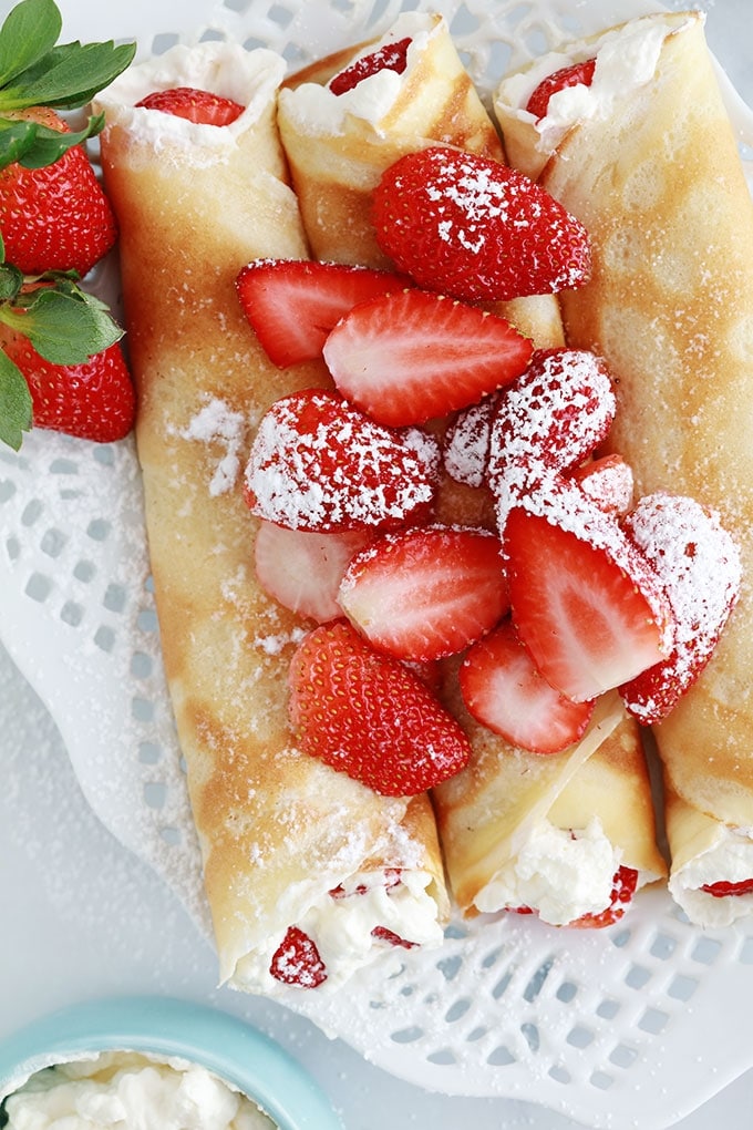 Crepes fourrees de fraises et creme chantilly dans un plat de service