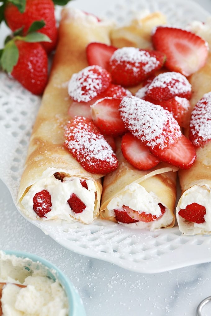 Crepes fourrees de fraises et creme chantilly dans un plat de service