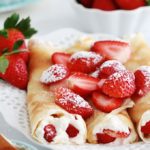 Crepes fourrees de fraises et creme chantilly dans un plat de service