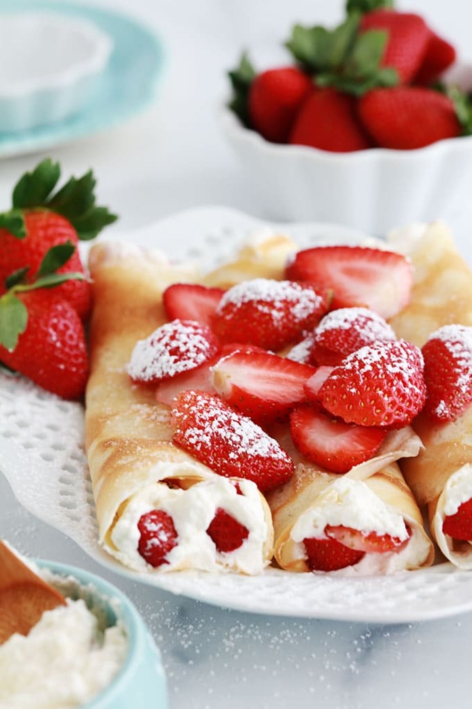 Crepes fourrees de fraises et creme chantilly dans un plat de service