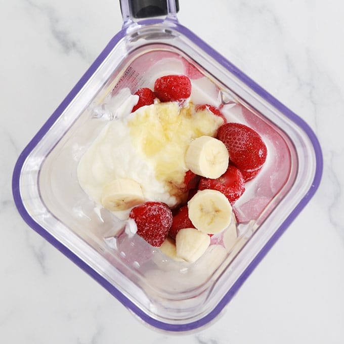 Fraises surgelees banane yaourt miel dans le bol du blender