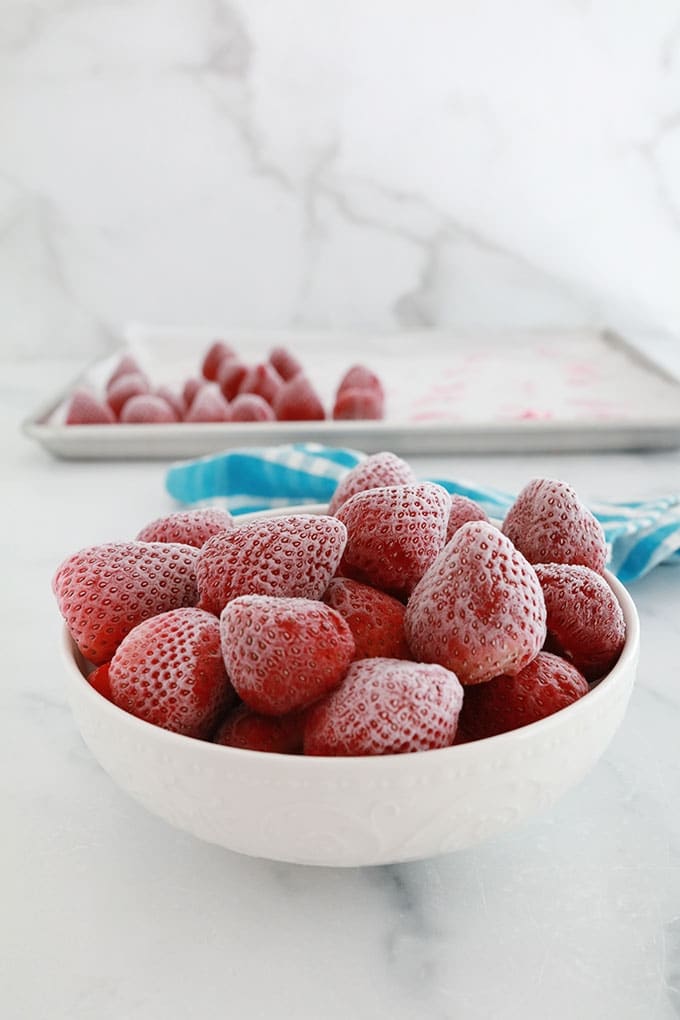 Fraises congelées dans un bol et dans une plaque